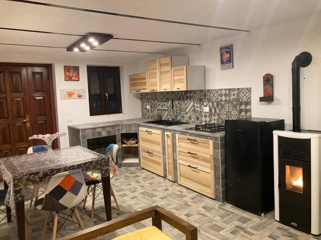 una cucina con frigorifero nero e tavolo di CASA MUPI a SantʼEufemia a Maiella