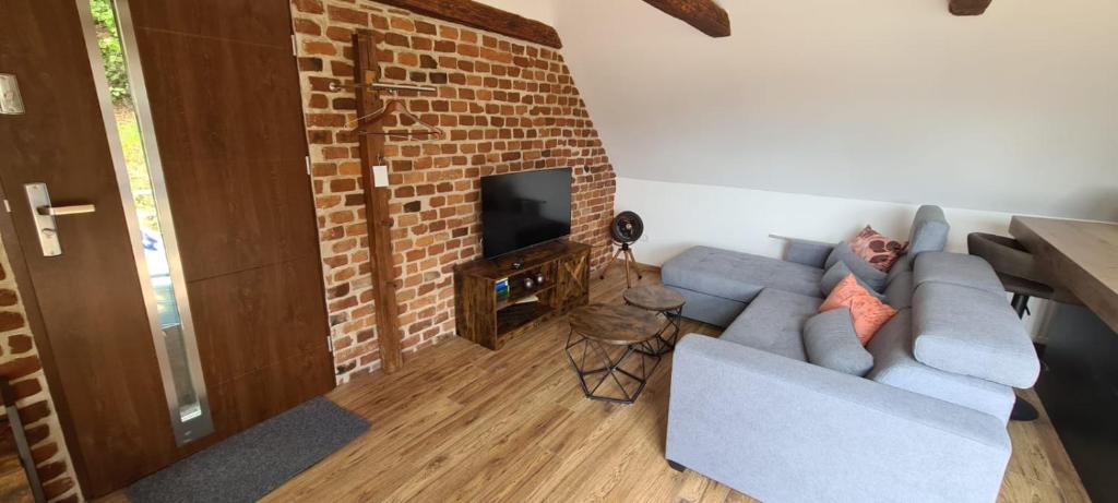 a living room with a blue couch and a brick fireplace at Apartments Nähe Red Bull Ring in Proleb