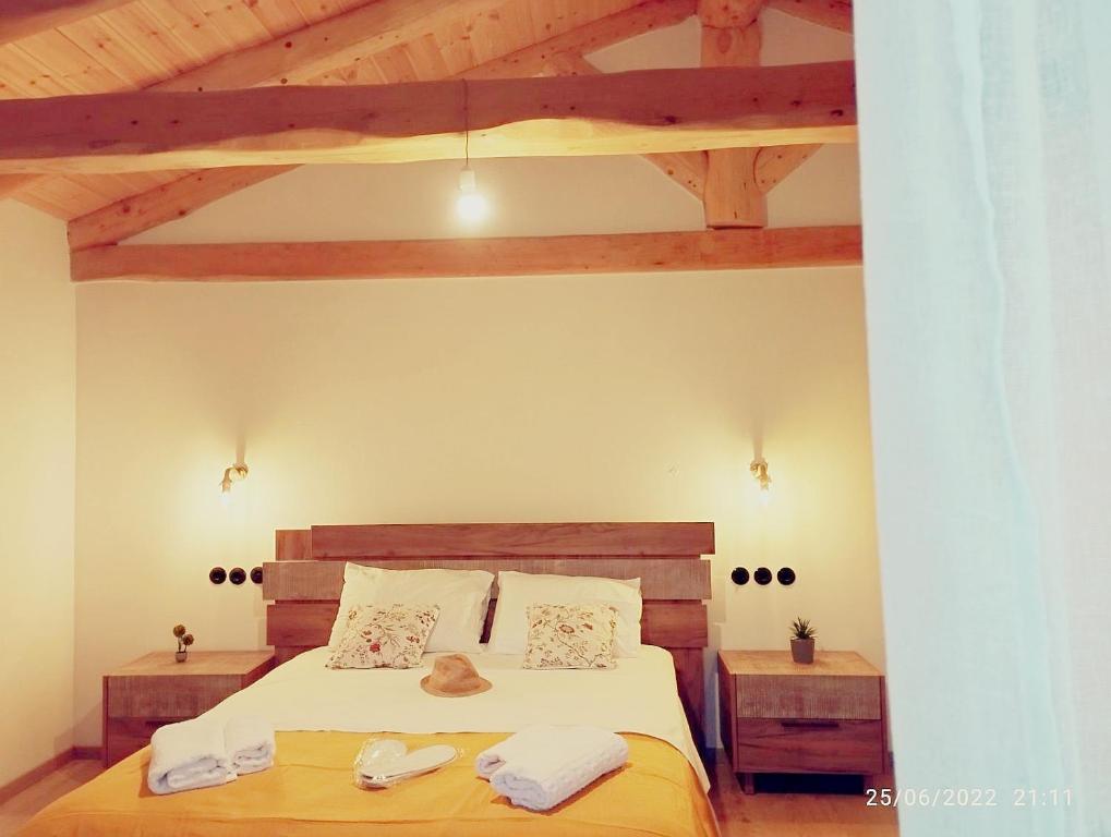 een slaapkamer met een bed en een houten plafond bij Spiro's cottage by Alegria apartments in Vlachopoulátika