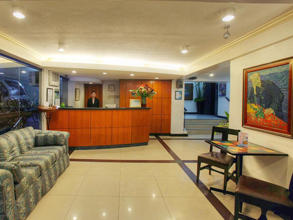 a lobby with a couch and a bar in a building at Fersal Hotel - Manila in Manila