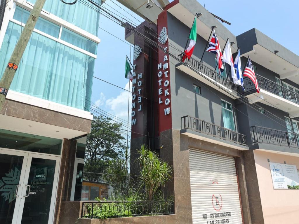 un bâtiment avec des drapeaux américains sur un balcon dans l'établissement Hotel Tamtokow, à Ciudad Valles