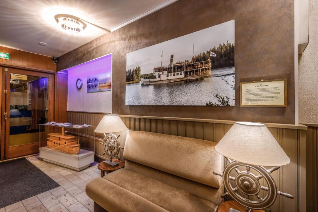 a waiting room with a couch and a picture of a boat at Majoitushuoneet Hotelli Tarjanne Virrat in Virrat