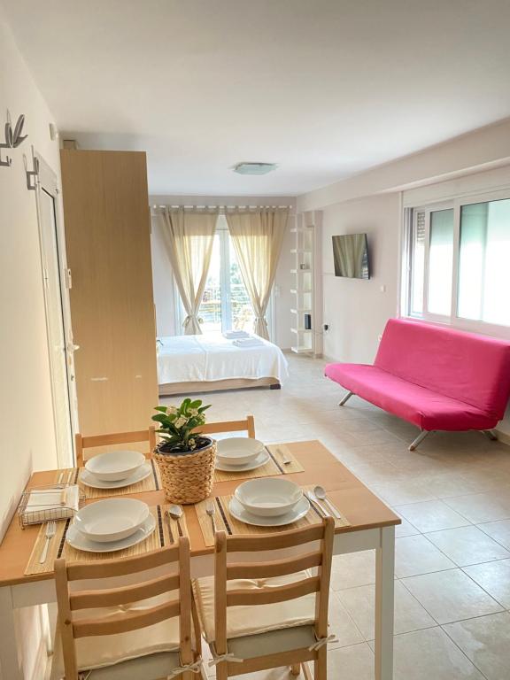 sala de estar con mesa y sofá rosa en Seaside one-bedroom on Chalkis en Chalkida