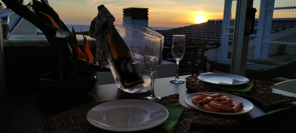 een tafel met een bord eten en een glas wijn bij Varandas do Mar in Arcozelo