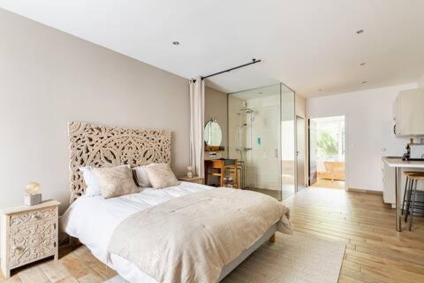 a bedroom with a large bed and a bathroom at Studio chic avec salon et terrasse privée in Tourcoing