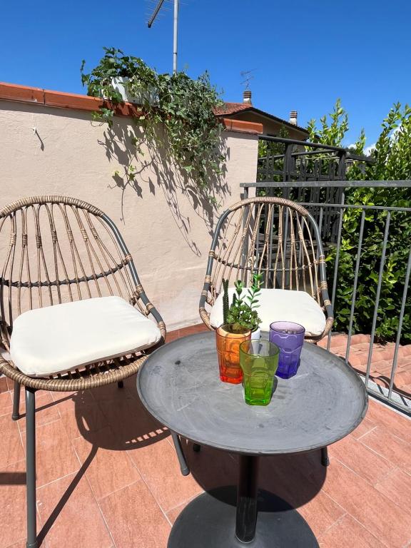 2 Stühle und ein Tisch auf der Terrasse in der Unterkunft Casa Lungarno in Empoli
