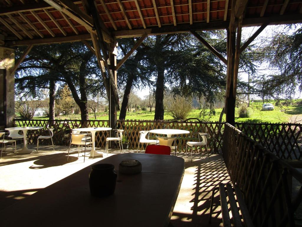 un patio con tavoli e sedie sotto un padiglione di Artémis a Caillavet