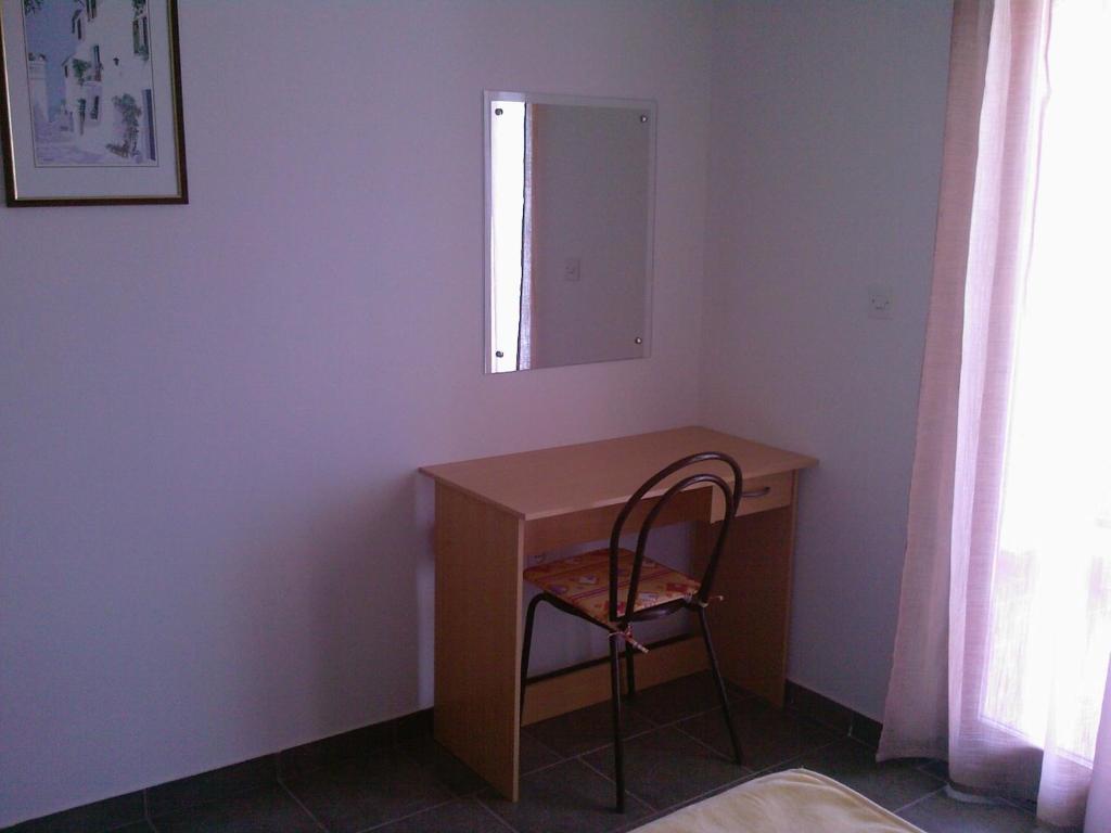 a desk in a room with a chair and a mirror at Apartments Meni in Drage