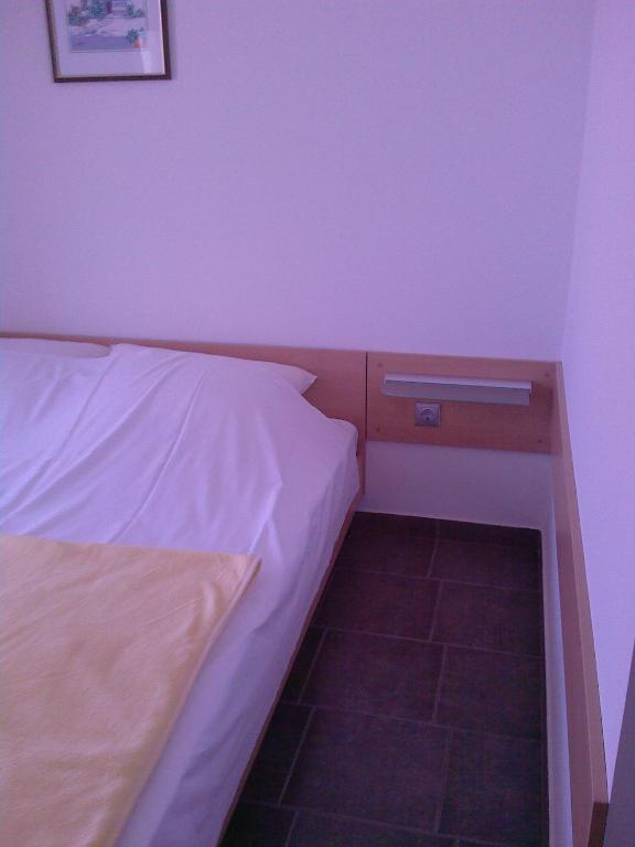a small bedroom with a bed and a desk at Apartments Meni in Drage