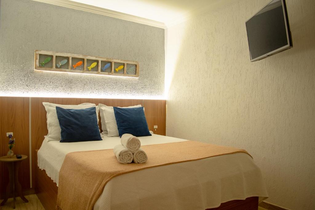 une chambre d'hôtel avec un lit et des serviettes. dans l'établissement Apartamento Privativo - Centro Búzios, à Búzios