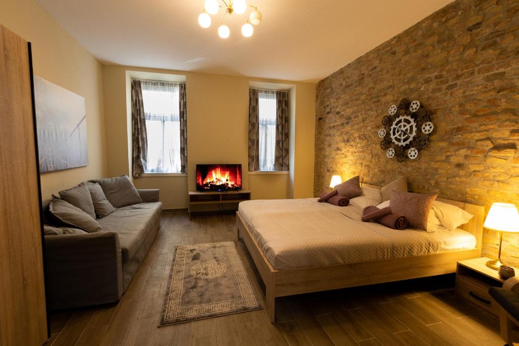 - une chambre avec un lit, un canapé et une cheminée dans l'établissement Comfortable romantic 1 bedroom apartment near Augarten, à Vienne