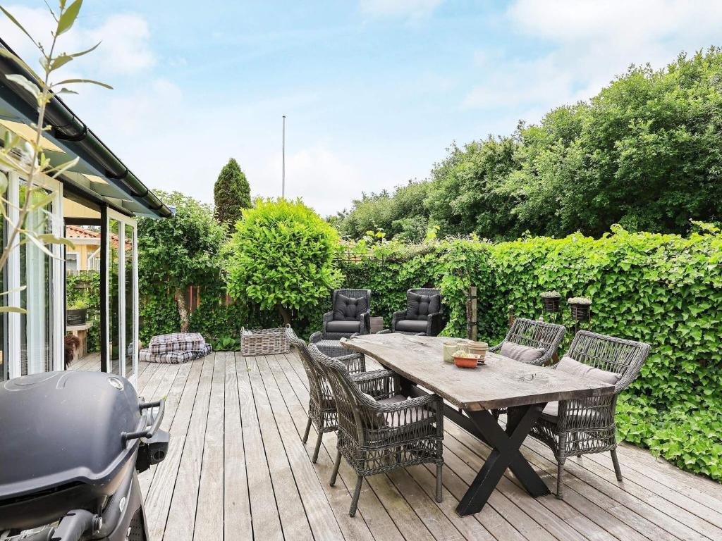 a wooden deck with a table and chairs and a scooter at 6 person holiday home in Karrebæksminde-By Traum in Karrebæksminde