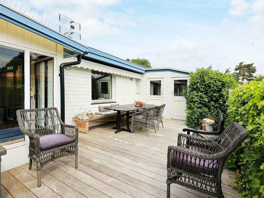 a wooden deck with chairs and a table on a house at 6 person holiday home in Karrebæksminde-By Traum in Karrebæksminde