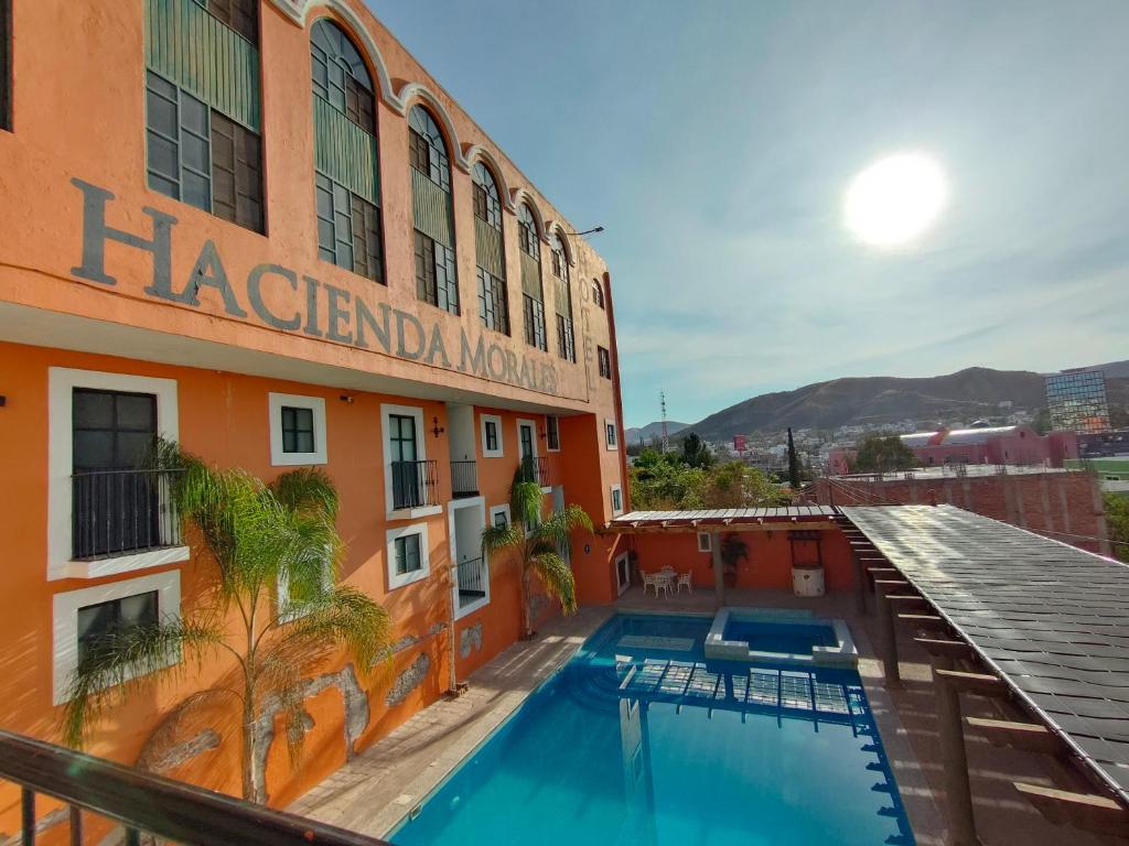 a hotel with a swimming pool in front of a building at Hotel Hacienda Morales. in Guanajuato