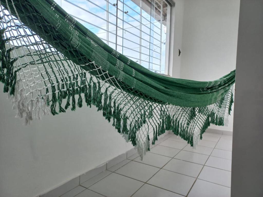 a large green net in a room with a window at Apartamento no Sítio Histórico de Olinda in Olinda