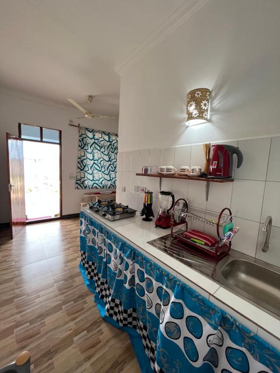 a kitchen with a blue and white counter top at Amos House in Kendwa