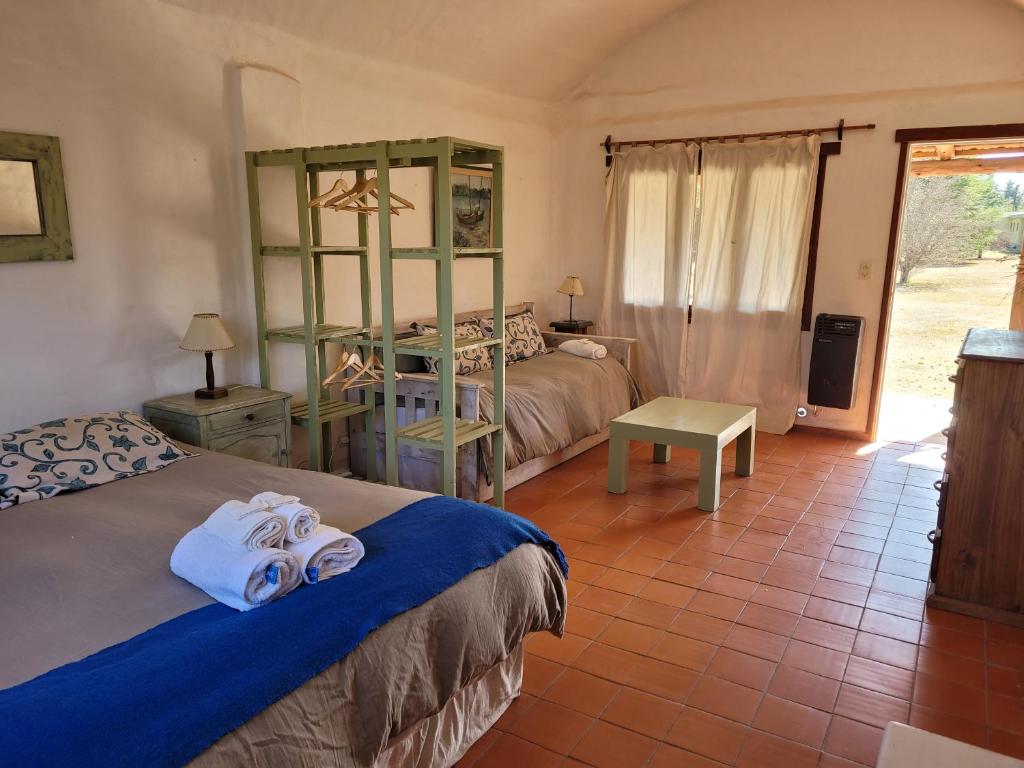 a bedroom with two beds with towels on them at Posada Buen Camino in Nono