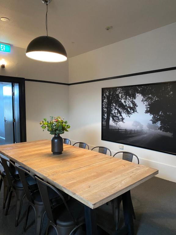 a conference room with a wooden table and a large screen at Tattersalls Hotel in Goulburn