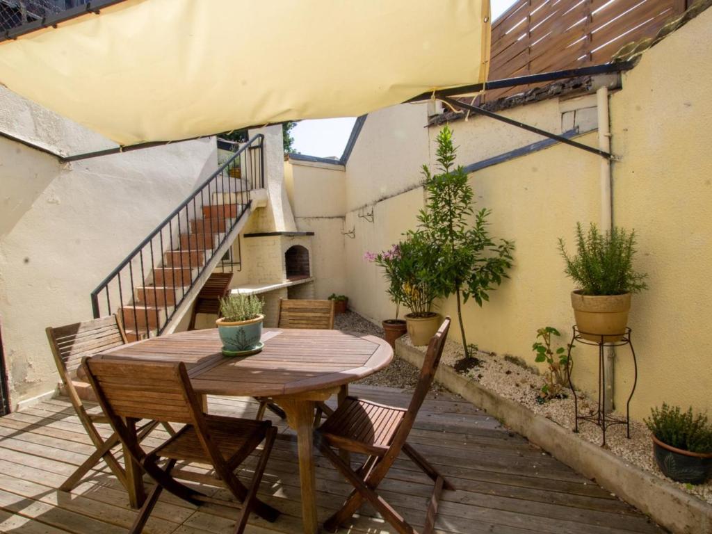 einen Holztisch und Stühle auf einer Terrasse mit einer Treppe in der Unterkunft Gîte Bergerac, 4 pièces, 6 personnes - FR-1-616-271 in Bergerac