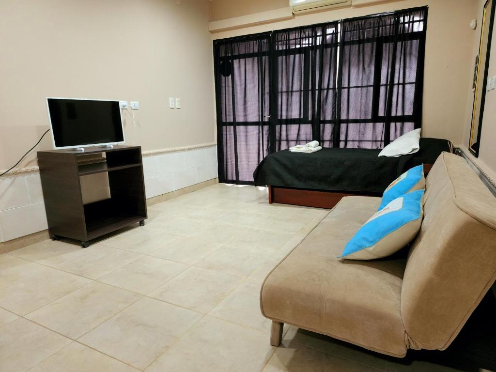 a living room with a couch and a television at Departamento Sarmiento in Rosario de la Frontera