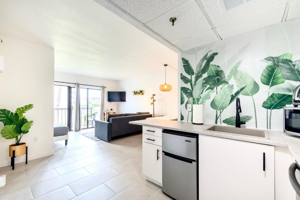 a kitchen with white cabinets and plants on the wall at Studio near Universal Studios with great view in Orlando