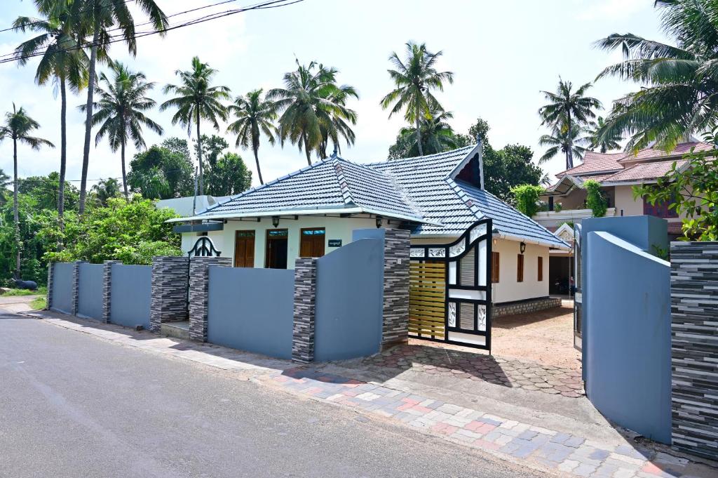 a house with a gate in front of it at Kollakudy HomeStay in Paravūr