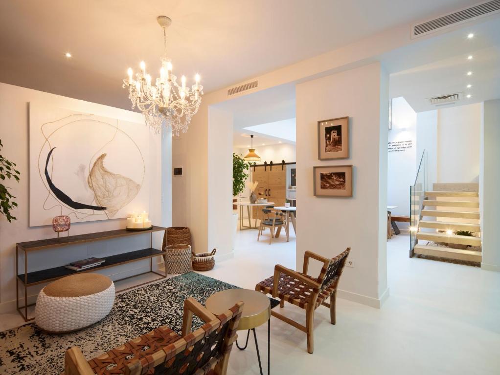 a living room with a chandelier and a table and chairs at LD Convento Cister in Málaga