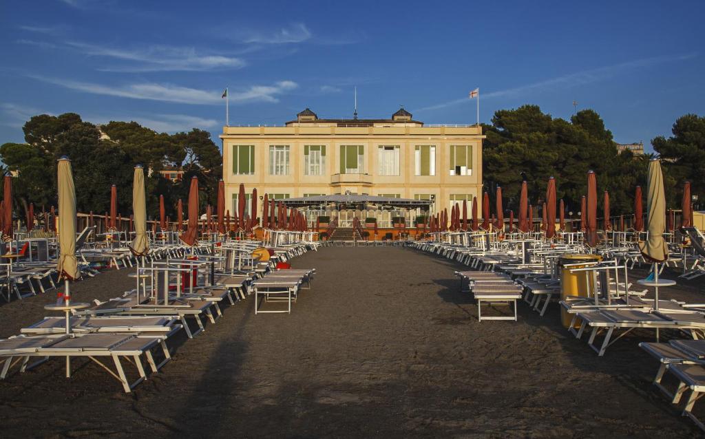 a group of chairs and umbrellas in front of a building at Suite Hotel Nettuno in Sestri Levante
