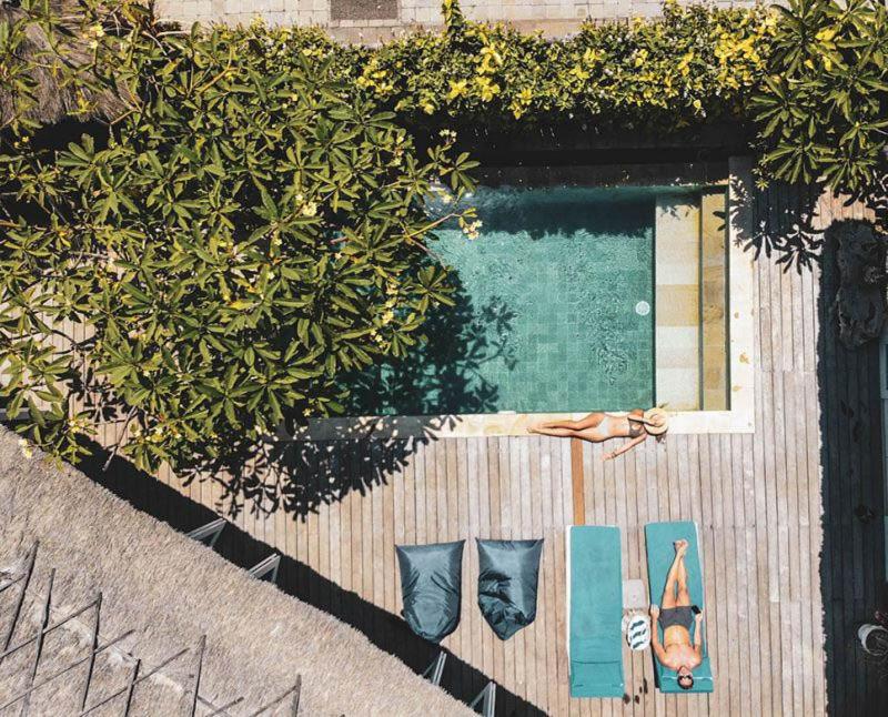 a woman laying on the ground next to a swimming pool at Villa Escape in Nusa Lembongan