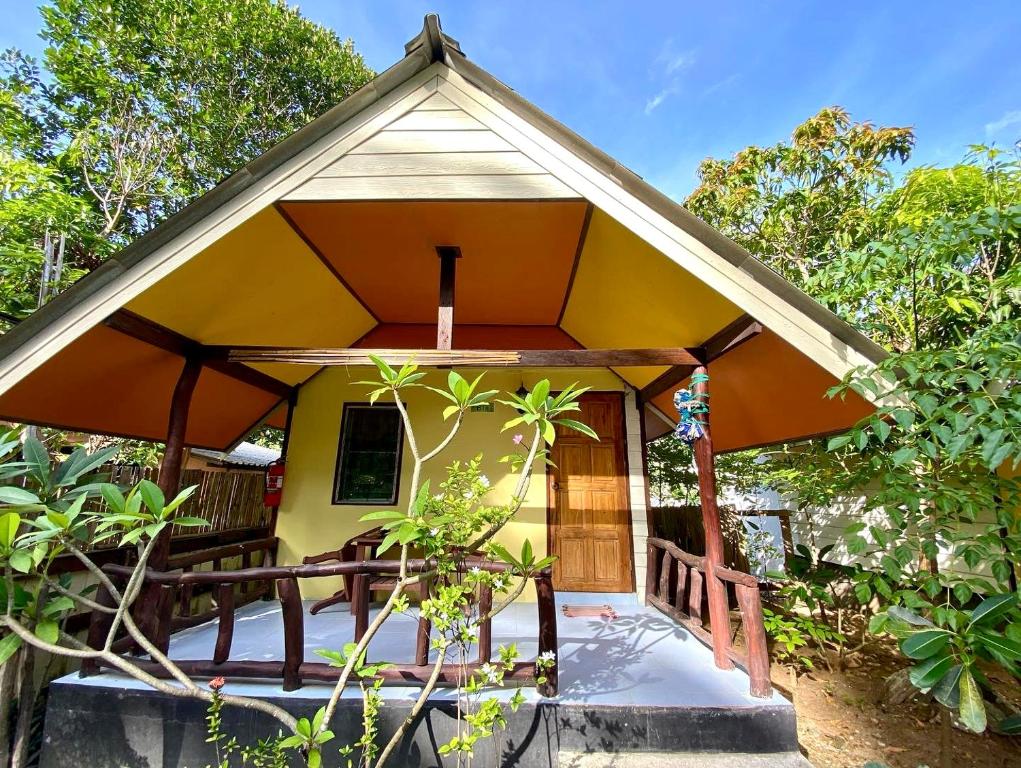 a small yellow cottage with a thatched roof at Long Beach Garden Resort in Ko Lanta