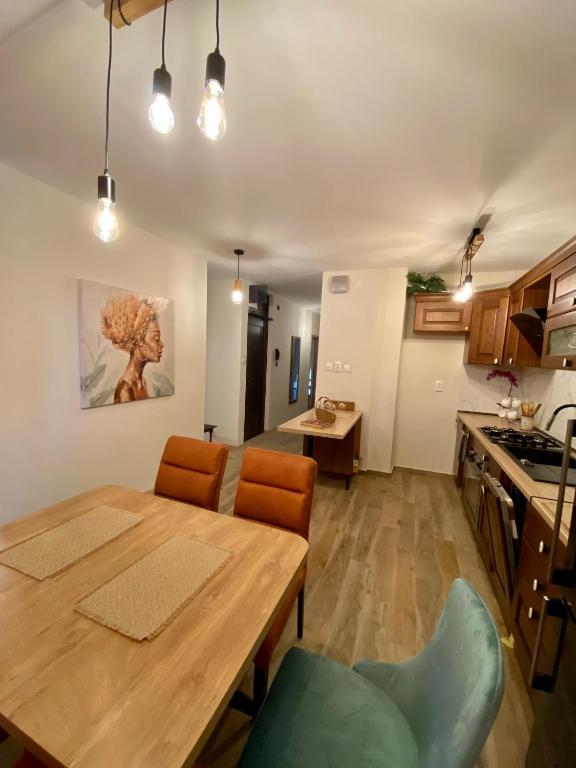 cocina y comedor con mesa de madera y sillas en New Apartment with balcony and free parking, en Zadar