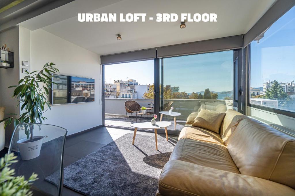 a living room with a couch and a large window at Urban Loft & Urban Flat 2024 in Kavala