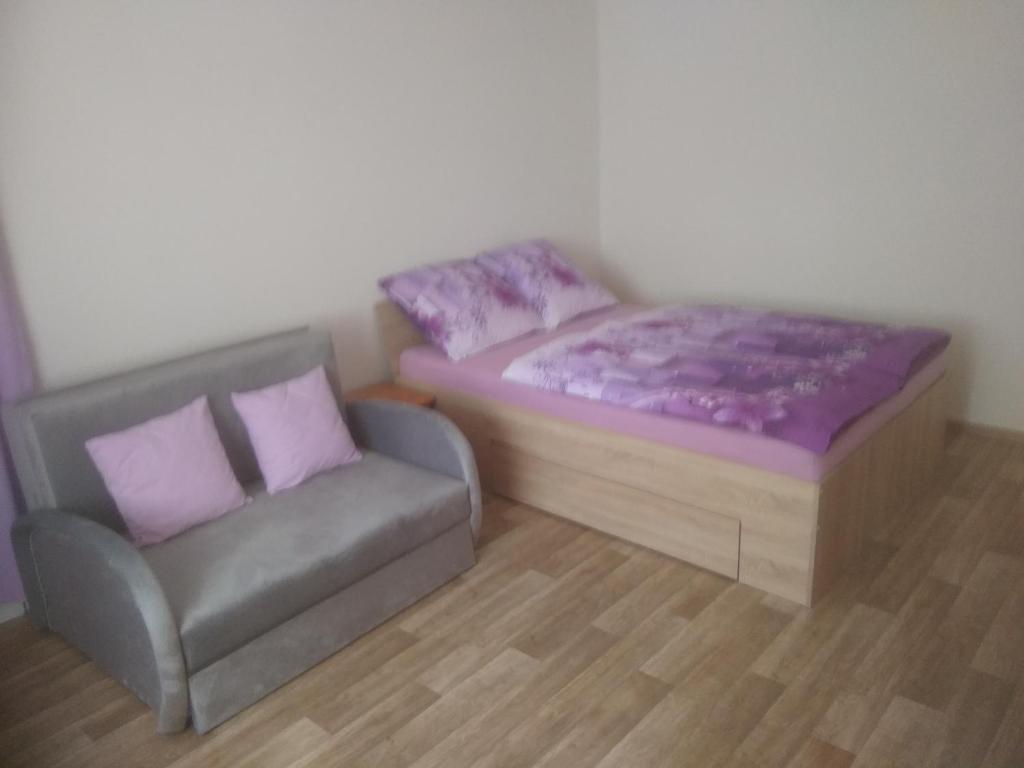 a bed and a couch in a room at Apartmány Toufar in Telč