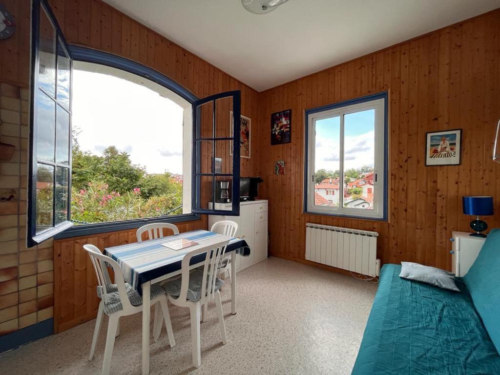 een kamer met een tafel en stoelen en 2 ramen bij Appartement Saint-Jean-de-Luz, 2 pièces, 2 personnes - FR-1-239-804 in Saint-Jean-de-Luz