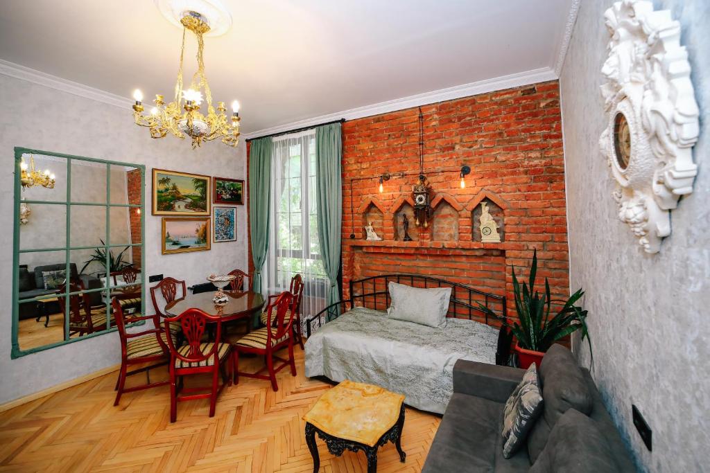 a bedroom with a brick wall and a bed and a table at Old Vera in Tbilisi City
