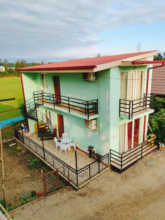 a green house with a table in front of it at Green Cottage in Ureki