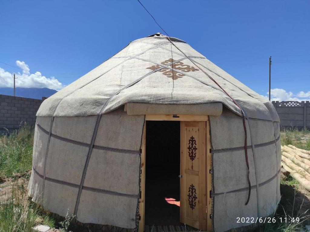 a large dome tent with a door in a field at Guest house and Yurt camp "Ailuu" in Tong