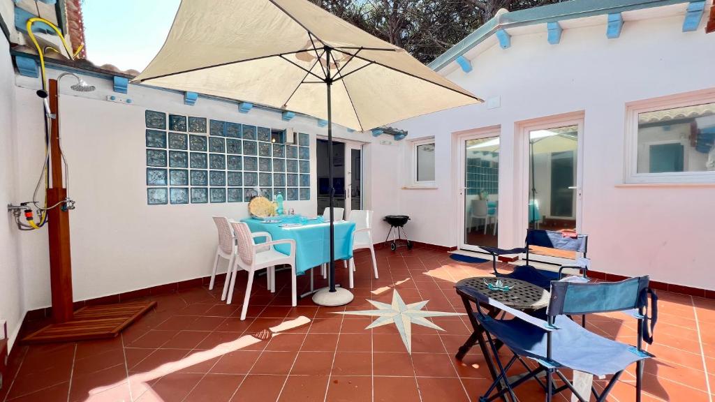un patio con mesa y sombrilla en Turquoise Sea House, en Santa Lucia