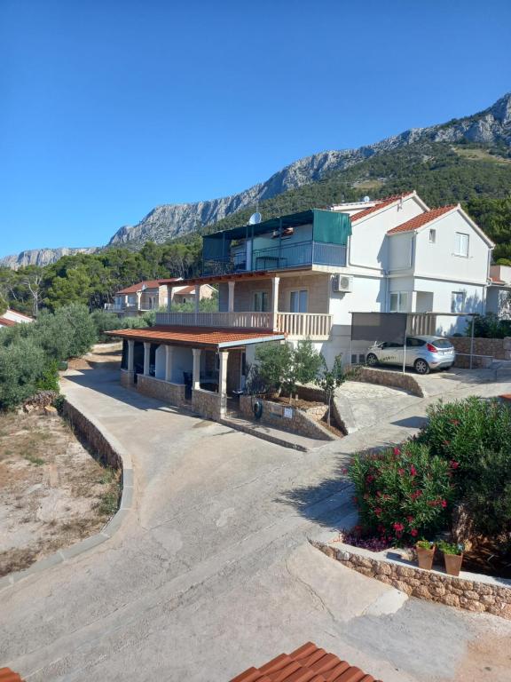 a house with a mountain in the background at Apartments Berti in Sveta Nedelja