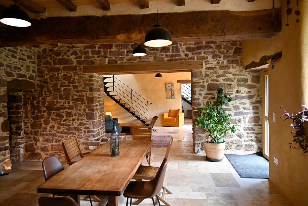 LES CHAMBRES AUX LOUPS في Iffendic: غرفة طعام مع طاولة وكراسي خشبية