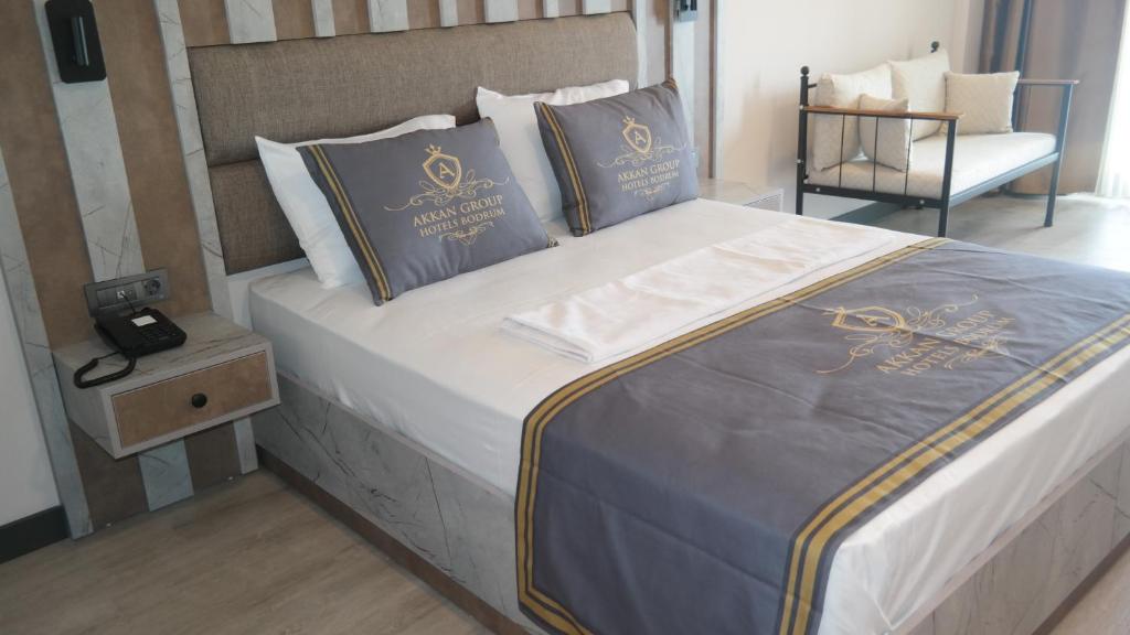 a bed with two pillows and a phone on it at ByAKKAN HOTEL in Bodrum City