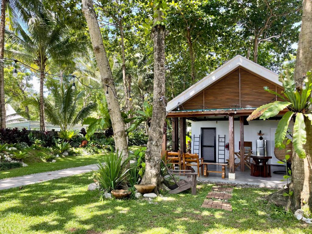 ein kleines Haus in einem Garten mit Bäumen in der Unterkunft Casa De Rosa in Dipolog City