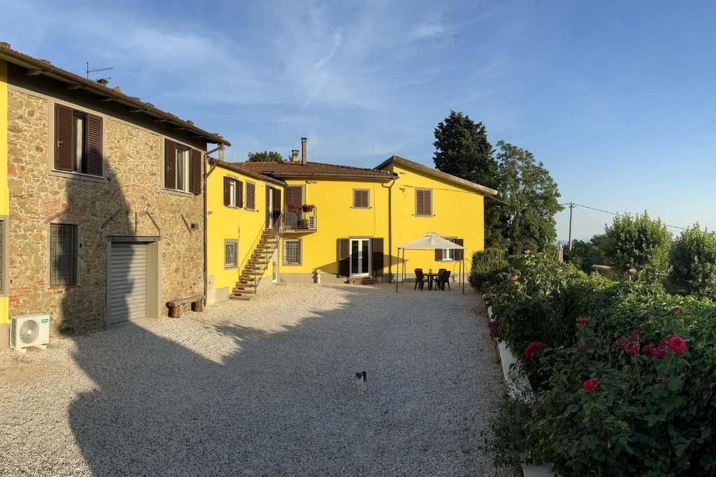 a yellow house with a pathway in front of it at il Podere La Casina in Monsummano