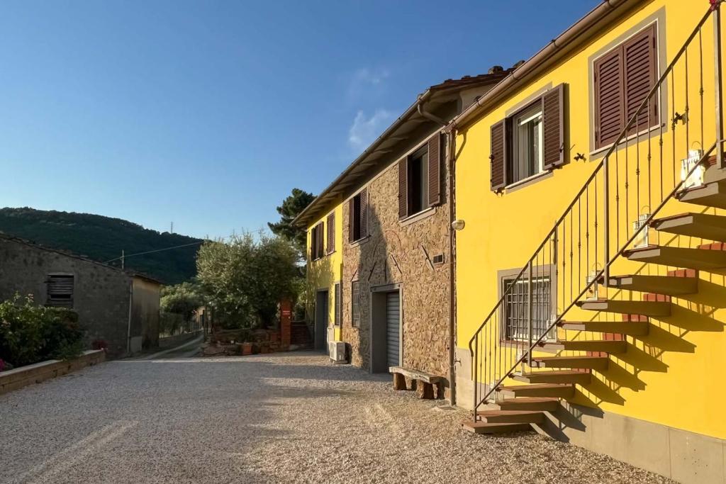 a yellow building with stairs on the side of a street at il Podere La Casina in Monsummano Terme