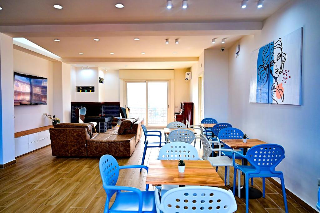 a waiting room with blue chairs and tables at Kore suites&apartments in Locri