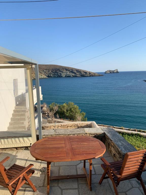 - une table et des chaises sur une terrasse avec vue sur l'océan dans l'établissement Ikia Wide Wild Summer House, à Kollimpithra