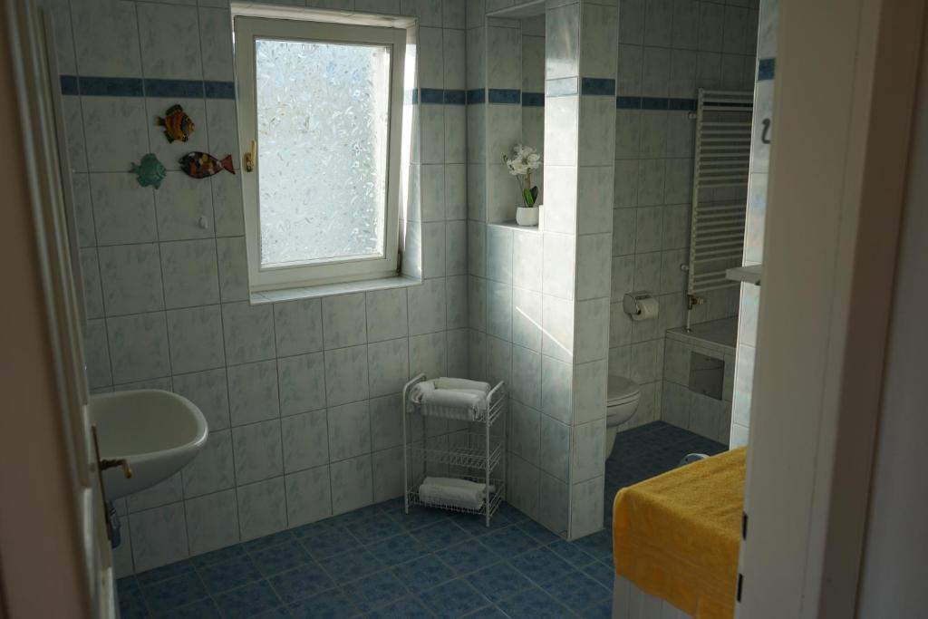 a bathroom with a sink and a toilet and a window at Landhaus im Hartbergerland in Hartberg