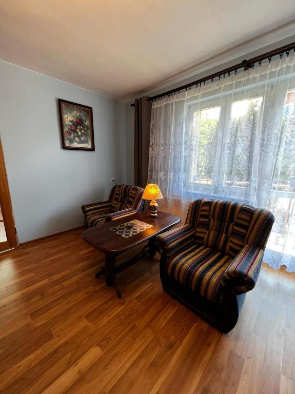a living room with two chairs and a table at Apartament Rodzinny in Rumia
