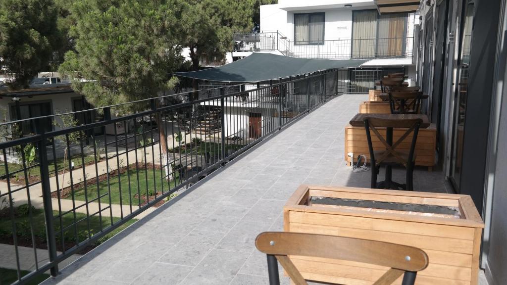 a balcony with chairs and tables and a fence at ByAKKAN HOTEL in Bodrum City