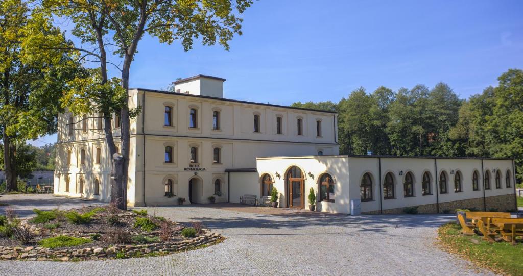 um grande edifício branco com muitas janelas em Hotel Stary Młyn em Suchedniów